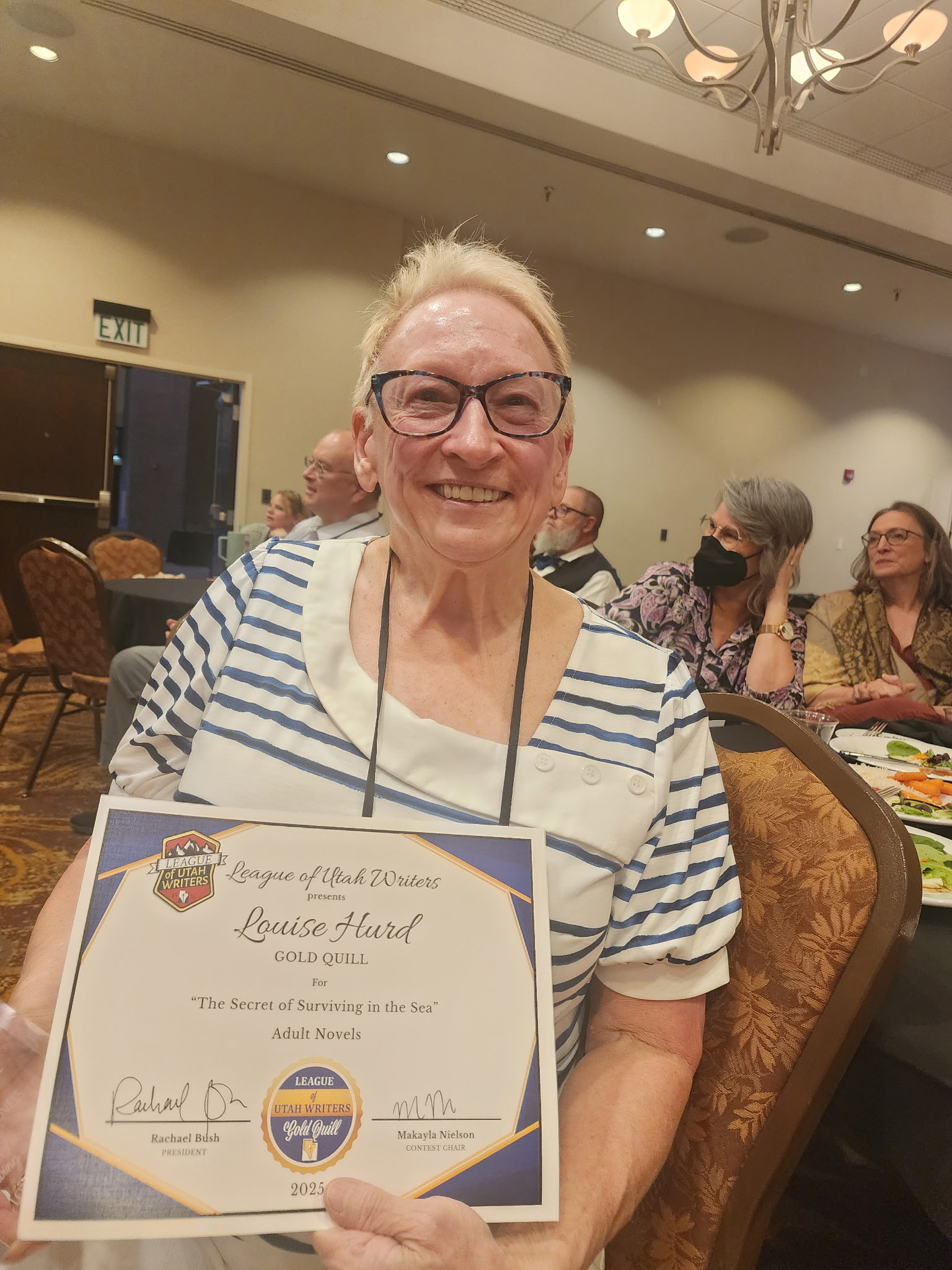 picture of Louise holding her Gold Quill award